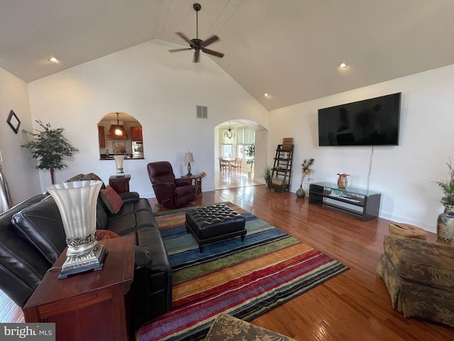 living area with visible vents, high vaulted ceiling, a ceiling fan, wood finished floors, and arched walkways