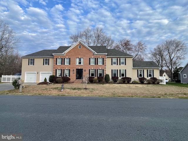 view of front of property with driveway, a garage, and fence