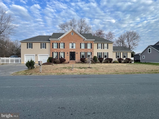 view of front of home featuring driveway, an attached garage, fence, and a front yard
