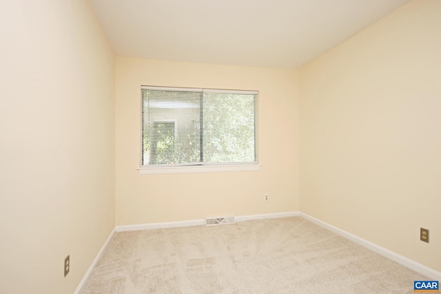 empty room featuring carpet flooring, baseboards, and visible vents