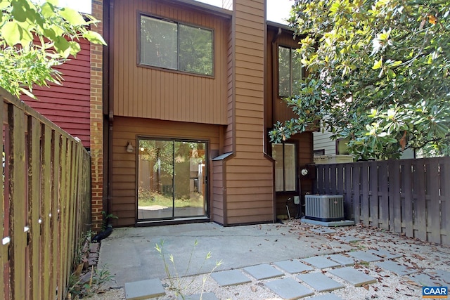 back of property featuring fence, central AC, a chimney, and a patio area