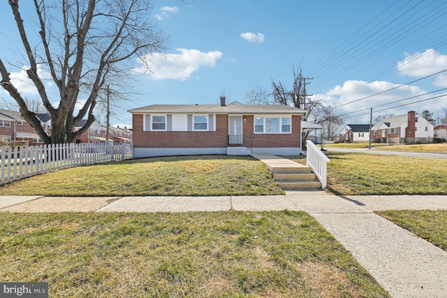 view of front facade featuring a front lawn, fence, and brick siding