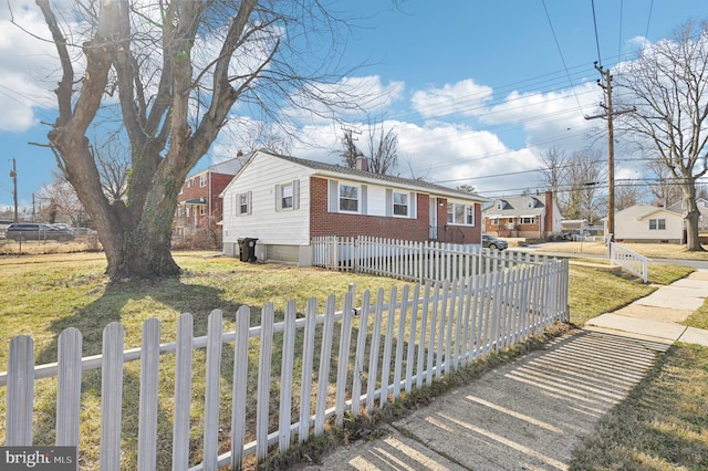 view of front of home featuring a fenced front yard, a front lawn, brick siding, and a chimney