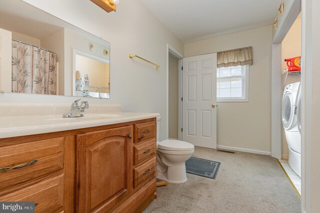 full bathroom featuring toilet, vanity, washer / dryer, and baseboards