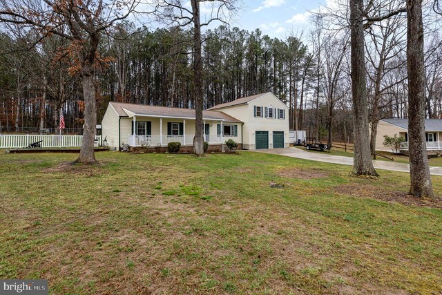 tri-level home with a front yard, a porch, concrete driveway, and a garage