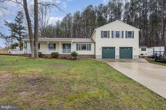 view of front of home featuring covered porch, driveway, an attached garage, and a front lawn