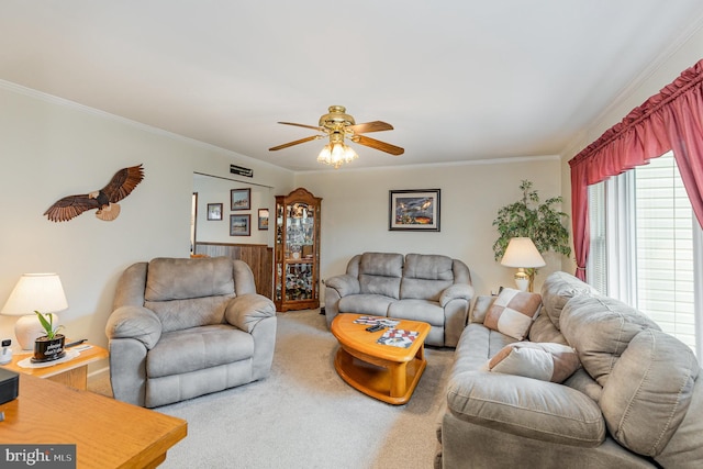 living room with ornamental molding, carpet, and a ceiling fan