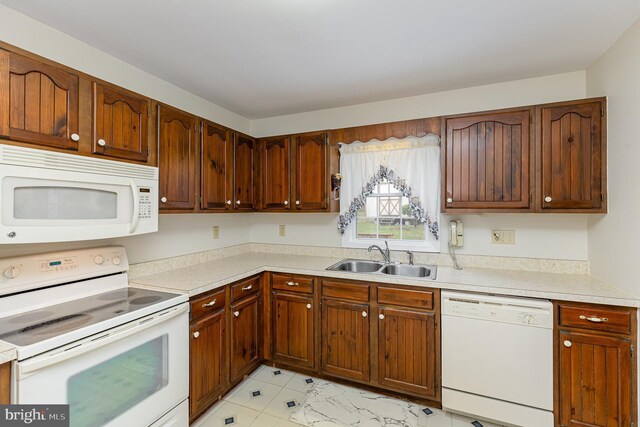 kitchen with light countertops, a sink, and white appliances