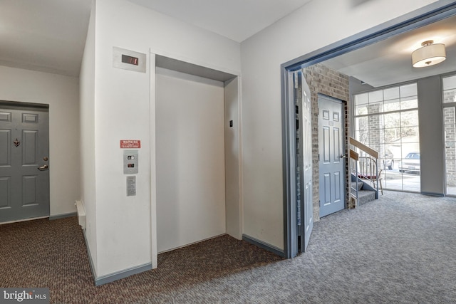 corridor with dark colored carpet, stairway, and elevator