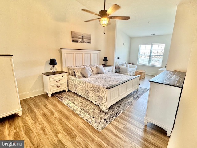 bedroom featuring visible vents, baseboards, light wood-style floors, and ceiling fan