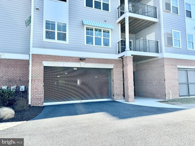 view of side of property with aphalt driveway and brick siding