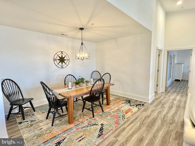 dining area featuring recessed lighting, baseboards, an inviting chandelier, and wood finished floors