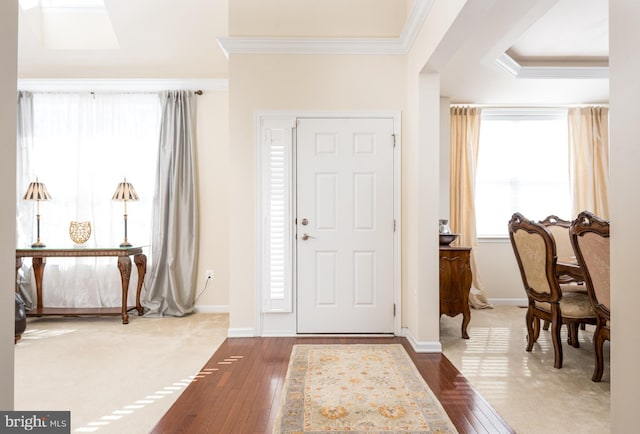 foyer featuring crown molding, baseboards, and wood-type flooring