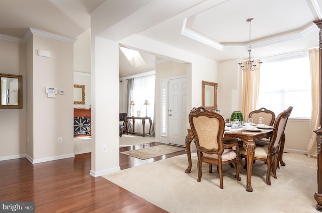 dining room featuring ornamental molding, baseboards, an inviting chandelier, and wood finished floors