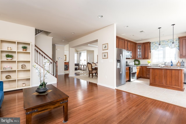 living area featuring stairway, visible vents, baseboards, recessed lighting, and light wood-style floors