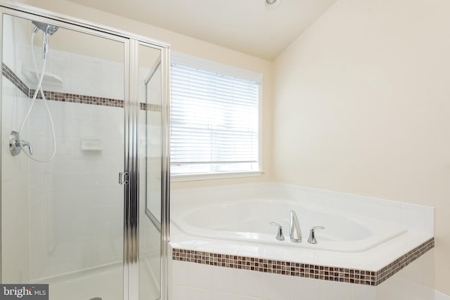 full bathroom featuring lofted ceiling, a garden tub, and a shower stall