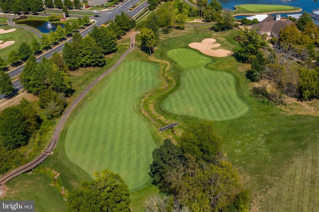 birds eye view of property with golf course view and a water view