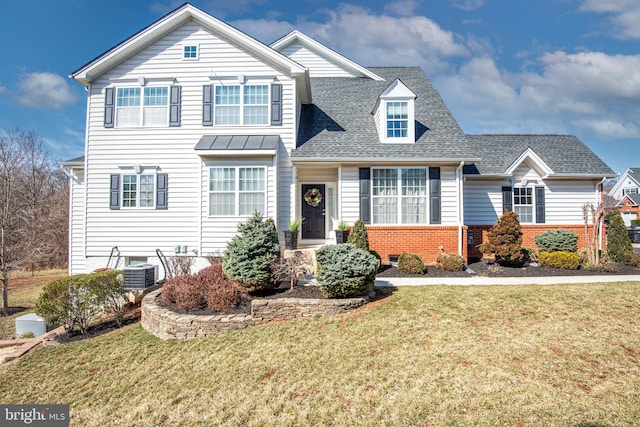 traditional-style home featuring brick siding, roof with shingles, and a front yard