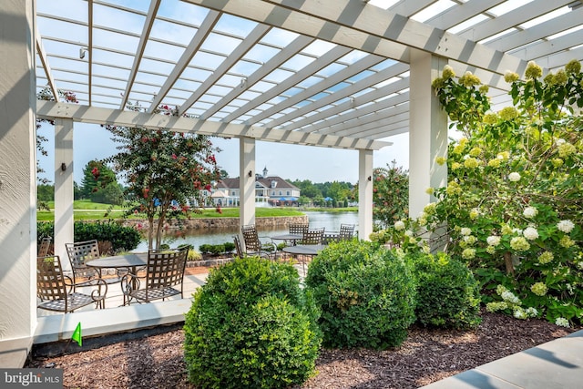 view of patio / terrace featuring outdoor dining area, a water view, and a pergola