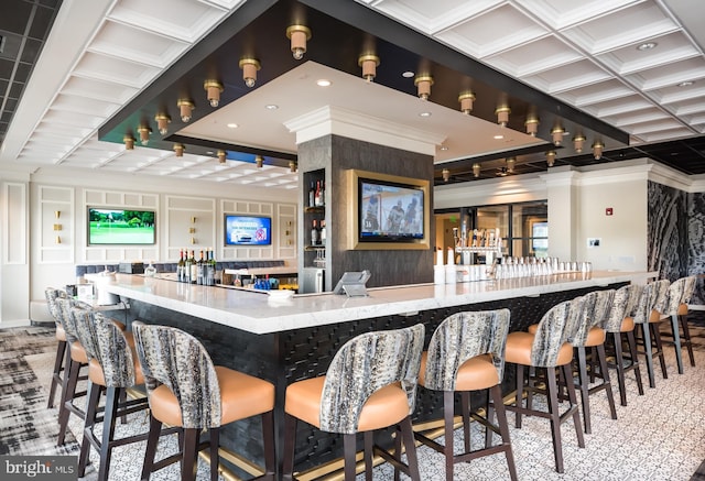 bar featuring a decorative wall, coffered ceiling, ornamental molding, and a community bar