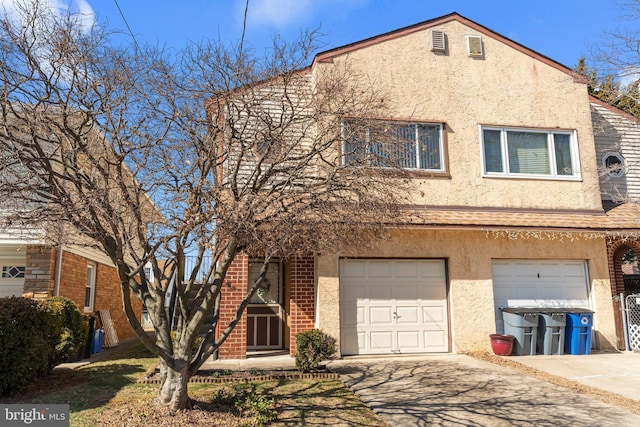 view of property with stucco siding, driveway, and an attached garage