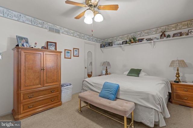 bedroom featuring a ceiling fan, light colored carpet, visible vents, and baseboards