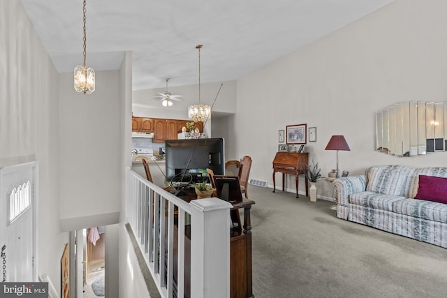 living room featuring visible vents, high vaulted ceiling, carpet, an inviting chandelier, and baseboards