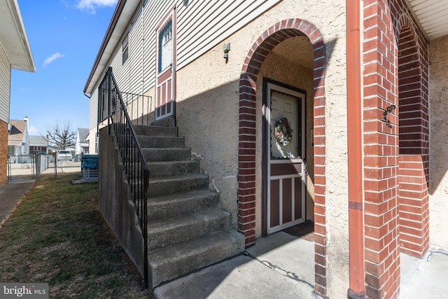 view of exterior entry featuring fence and a gate