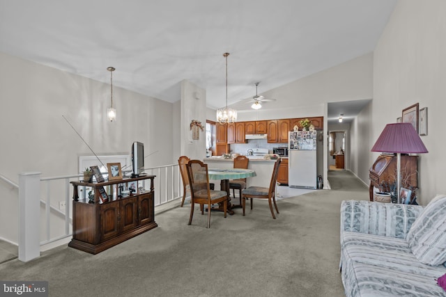 dining space featuring light colored carpet, a chandelier, and high vaulted ceiling