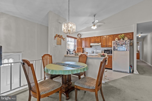 dining room featuring light carpet, light tile patterned flooring, a ceiling fan, and vaulted ceiling