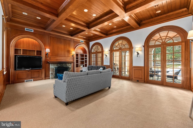 living room featuring carpet flooring, beamed ceiling, built in shelves, and wood ceiling