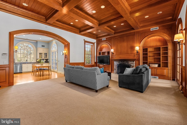 living room featuring visible vents, arched walkways, beamed ceiling, and wooden ceiling