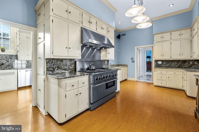 kitchen featuring dishwashing machine, double oven range, ornamental molding, under cabinet range hood, and backsplash