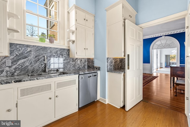 kitchen featuring a sink, stainless steel dishwasher, white cabinets, and light wood finished floors