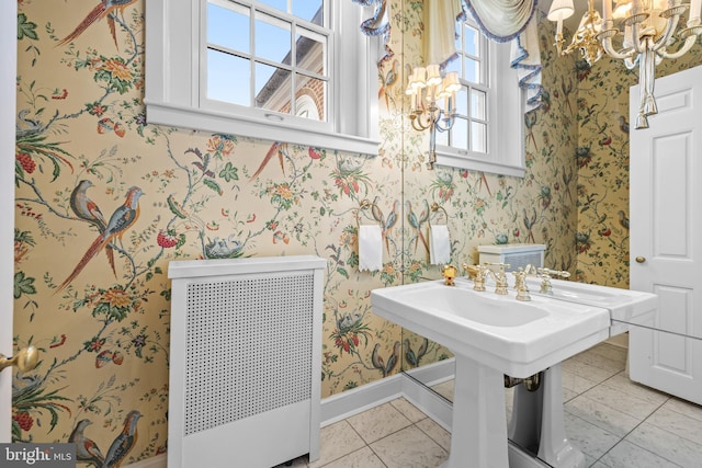 bathroom with wallpapered walls, baseboards, and a chandelier