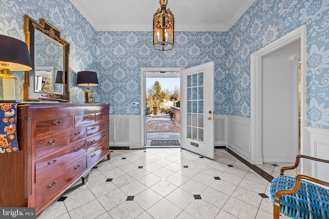 foyer entrance with wallpapered walls, crown molding, and wainscoting