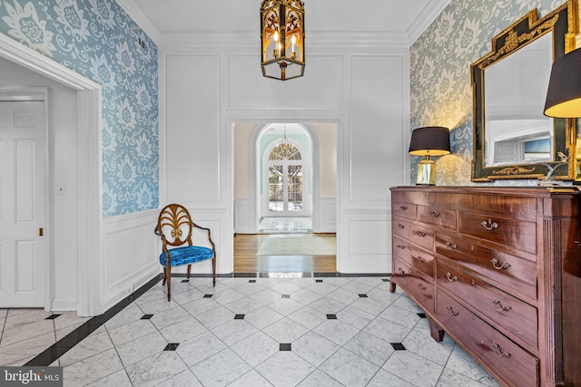 interior space featuring arched walkways, wainscoting, crown molding, and wallpapered walls