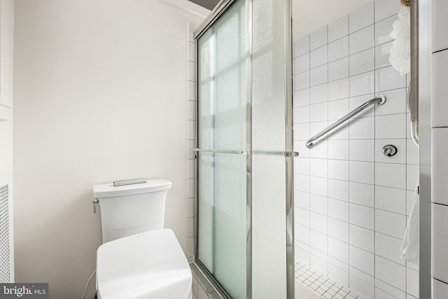 bathroom featuring a shower stall and toilet