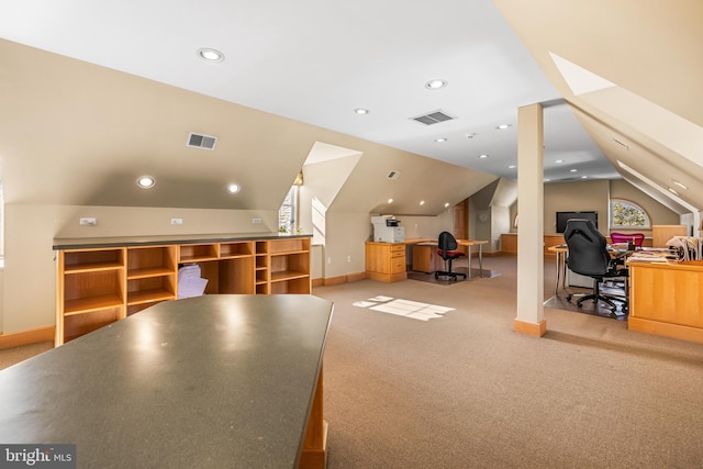 interior space featuring lofted ceiling with skylight, visible vents, and carpet