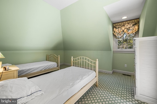 carpeted bedroom featuring lofted ceiling and baseboards