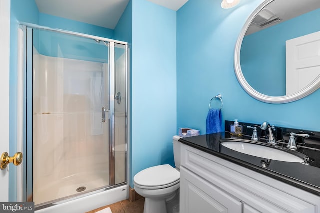 bathroom with tile patterned flooring, a shower stall, toilet, and vanity