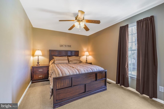 bedroom featuring light carpet, ceiling fan, and baseboards