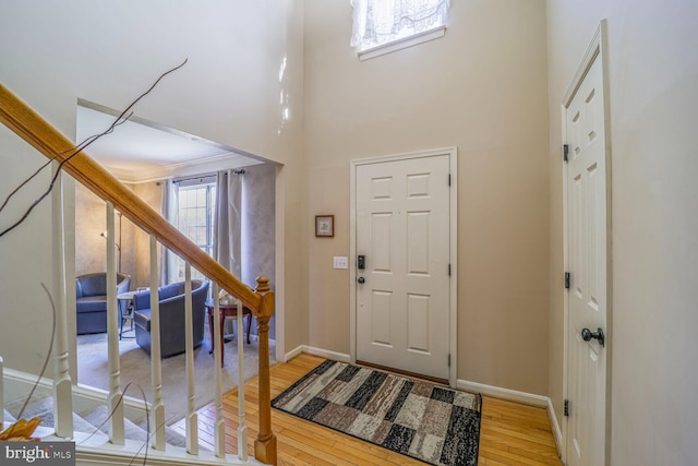 foyer featuring a high ceiling, baseboards, and wood finished floors