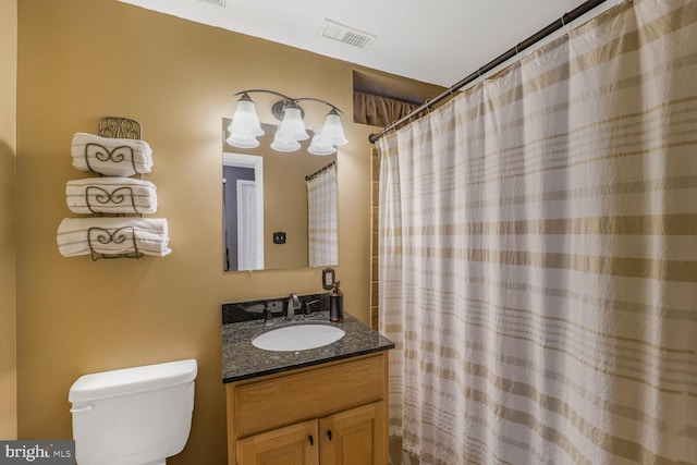 bathroom featuring visible vents, toilet, vanity, and a shower with curtain