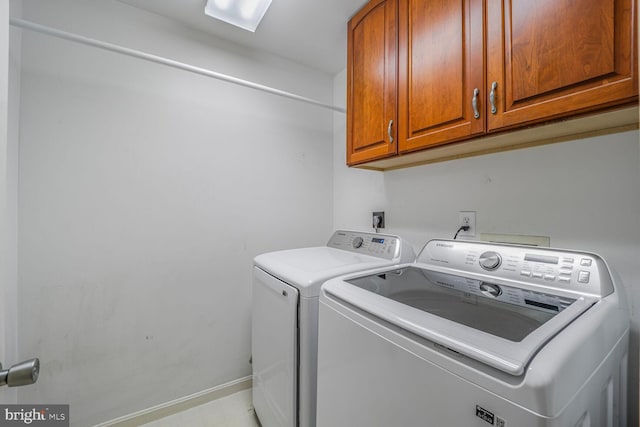 laundry area with washing machine and clothes dryer, cabinet space, and baseboards