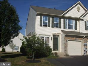 townhome / multi-family property featuring aphalt driveway and a garage