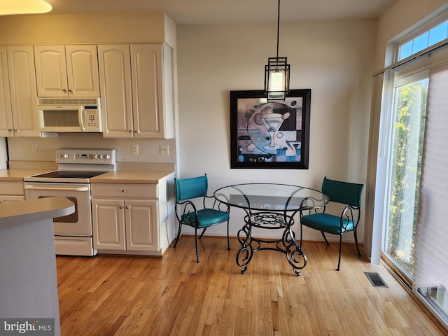 kitchen featuring white appliances, visible vents, light countertops, white cabinets, and light wood-type flooring