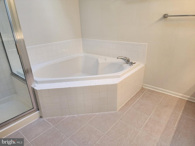 bathroom featuring tile patterned flooring, a garden tub, and a stall shower