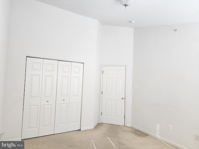 unfurnished bedroom featuring baseboards, a closet, and carpet floors