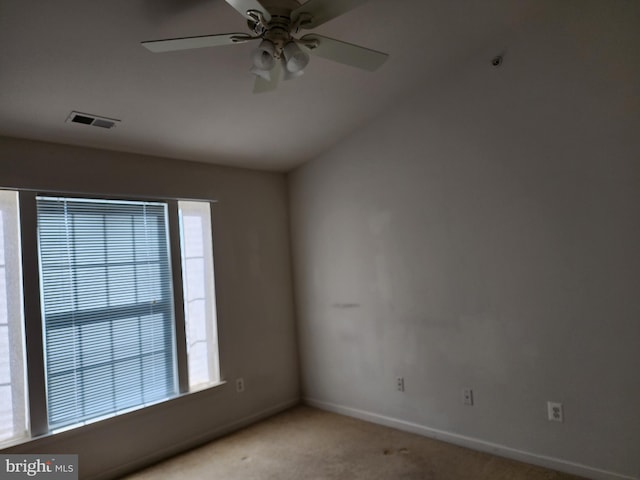 carpeted empty room featuring visible vents, baseboards, a ceiling fan, and vaulted ceiling